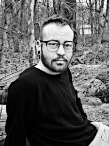 Black & white photo of Axton Mitchell in glasses and black sweater 