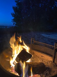 Campfire inside a fire ring on a beach 