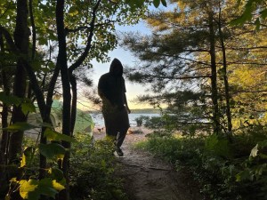 Axton walking in the forest toward lake superior