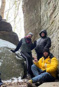 Axton in Jeans and a Yellow jacket, Kelsey in a black jacket behind axton, and kylie with a peace sign up behind axton aswell at cantwell cliffs 