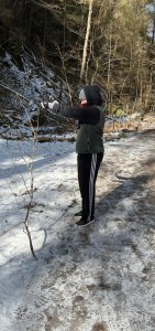 Kylie in her winter hiking clothes with a stick she found 