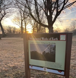 Sunset bare trans and a sign about the earthwork