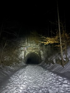 Moonville tunnel at night in the glow of snow.