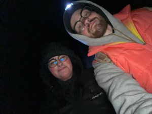 axton in grey hoodie and vest and Kelsey in black jacket 