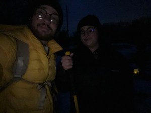 Axton in a yellow winter jacket and glasses with fiancé Kelsey in a black jacket and glasses