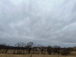 A winter field of brown grass lined with farmhouses and bare trees beside the trailhead at Rockbridge 