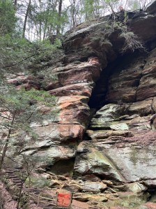Red and orange colored sandstone cliff walls in rockhouse section of hocking