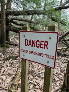 Danger cliffs white sign red writing